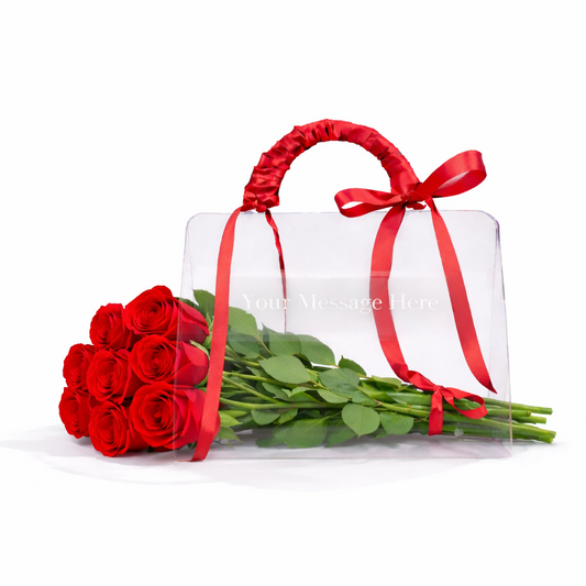 Bouquet of red roses with a clear gift box tied with a red ribbon on a white background