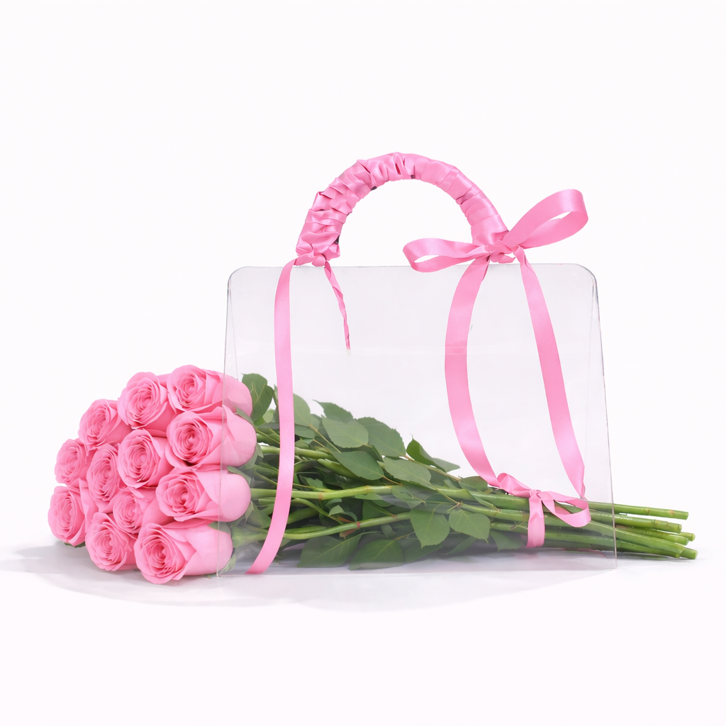 Clear handbag with pink handle and bow, accompanied by pink roses on a white background