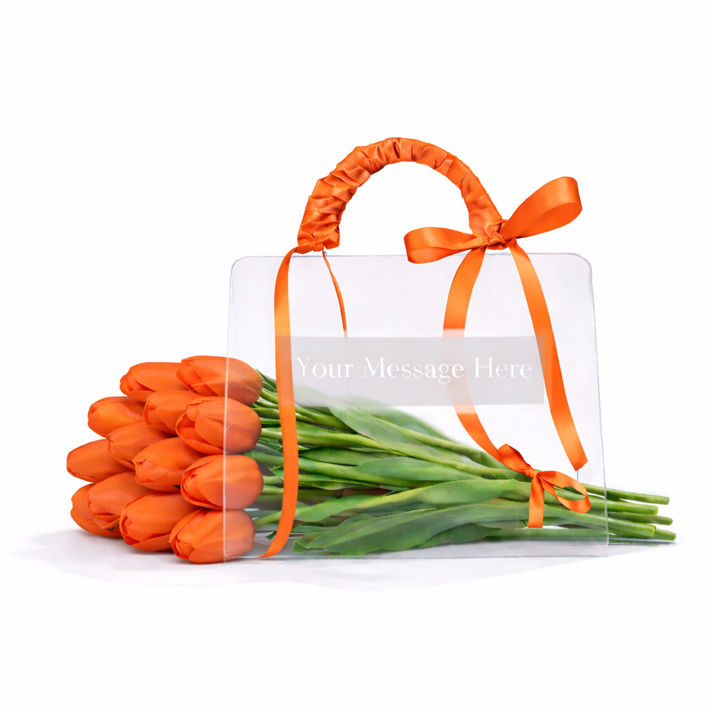 Bouquet of orange tulips with a clear card and orange ribbon on a white background