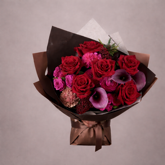 Bouquet of red and pink roses with brown paper wrapping on a beige background