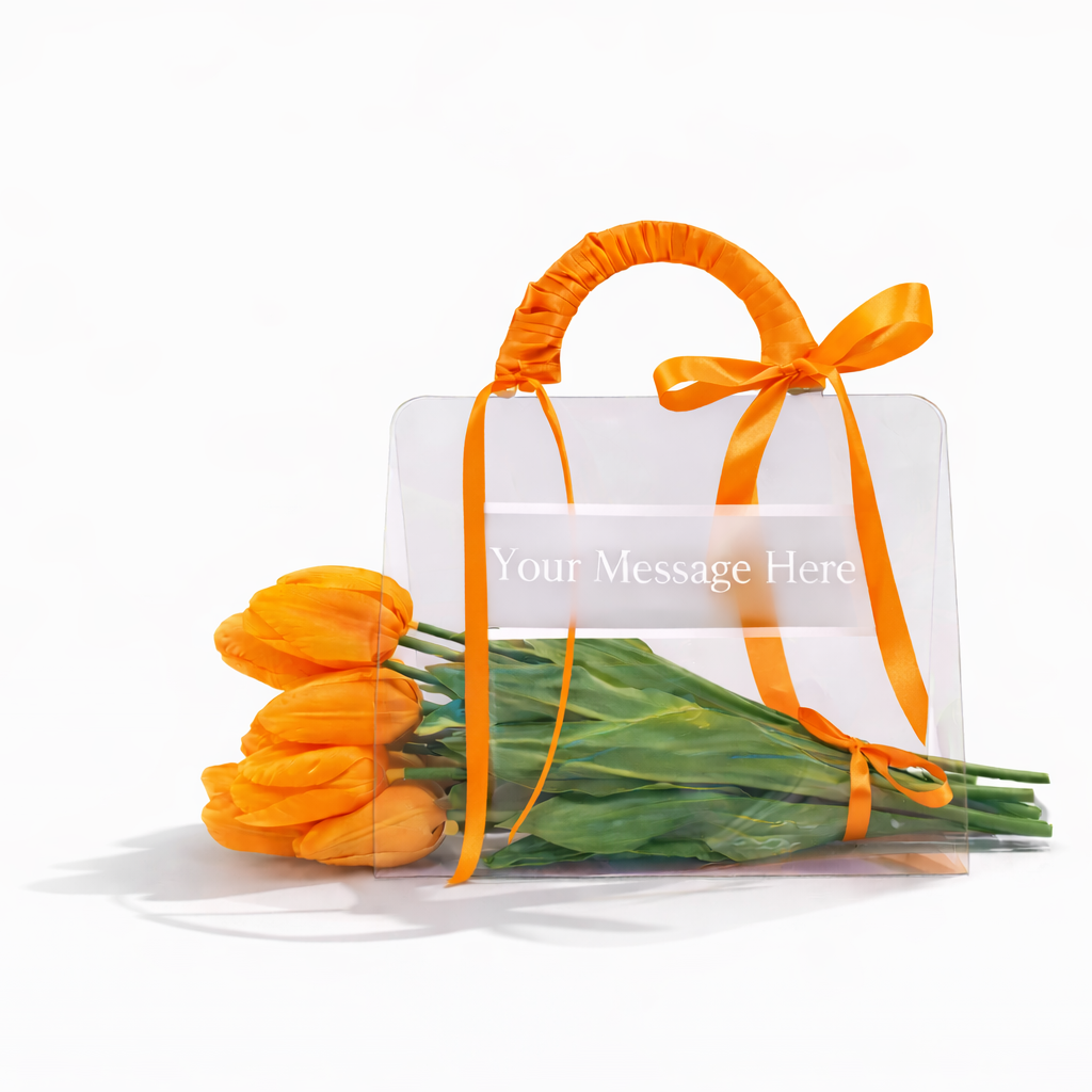 Bouquet of orange tulips with a clear gift bag and orange ribbon on a white background