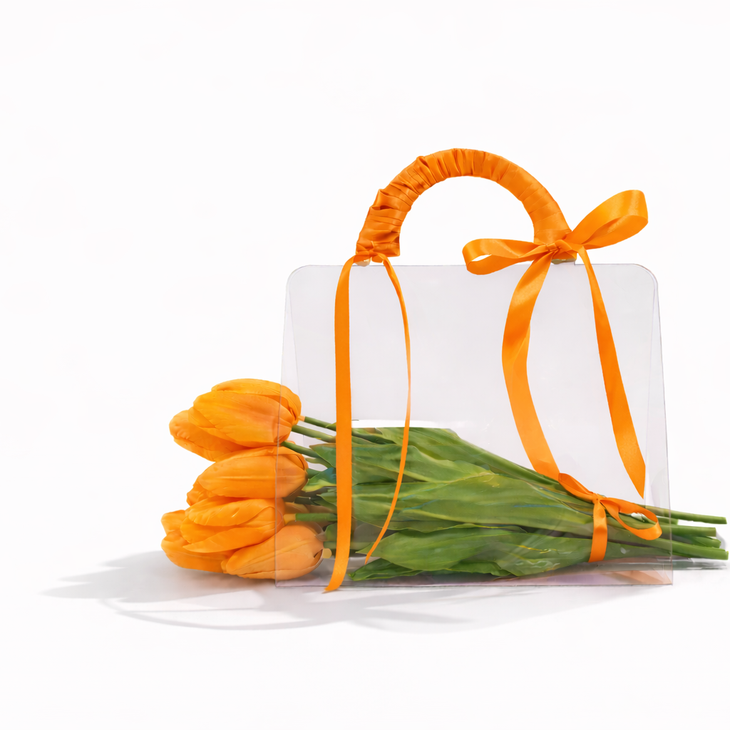 White gift box with orange ribbon and tulips on a white background